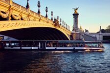 Barco Paris Seine navegando sob a Ponte Alexandre III ao pôr do sol