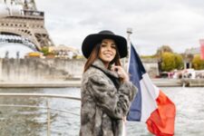 Smiling person aboard a Seine cruise boat with French flag and Eiffel Tower in the background